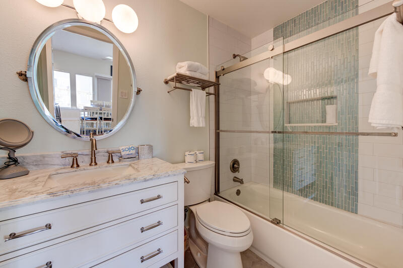 Bathroom with round mirror and tub shower