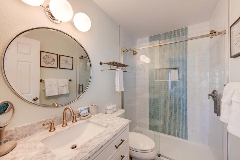 Bathroom with round mirror and glass shower